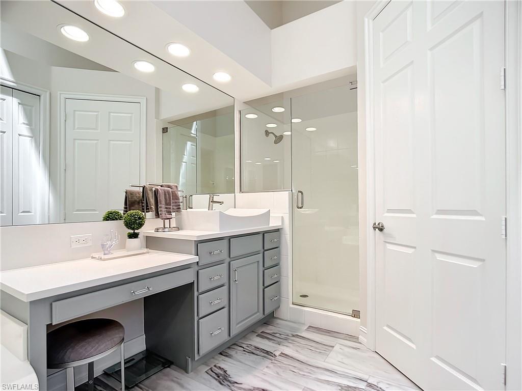 4752 Stratford Court, Unit 1404 Naples, FL 34105 - Photo 28 of 34 a bathroom with a sink double vanity and a mirror