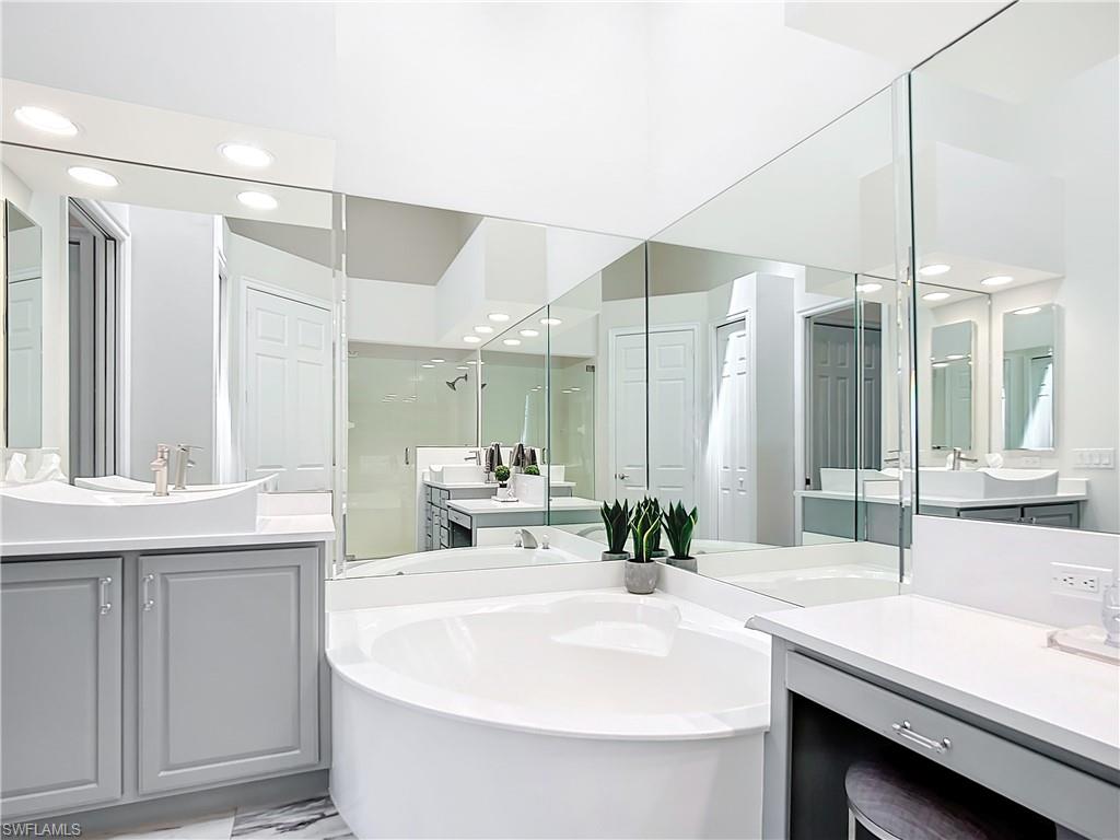 4752 Stratford Court, Unit 1404 Naples, FL 34105 - Photo 29 of 34 a bathroom with a sink and a mirror