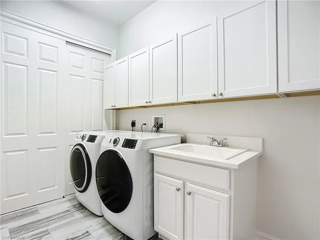 a utility room with sink dryer and washer