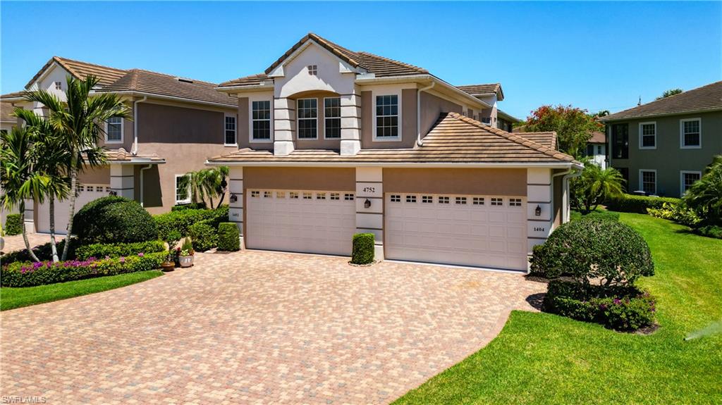 4752 Stratford Court, Unit 1404 Naples, FL 34105 - Photo 3 of 34 a front view of a house with a yard