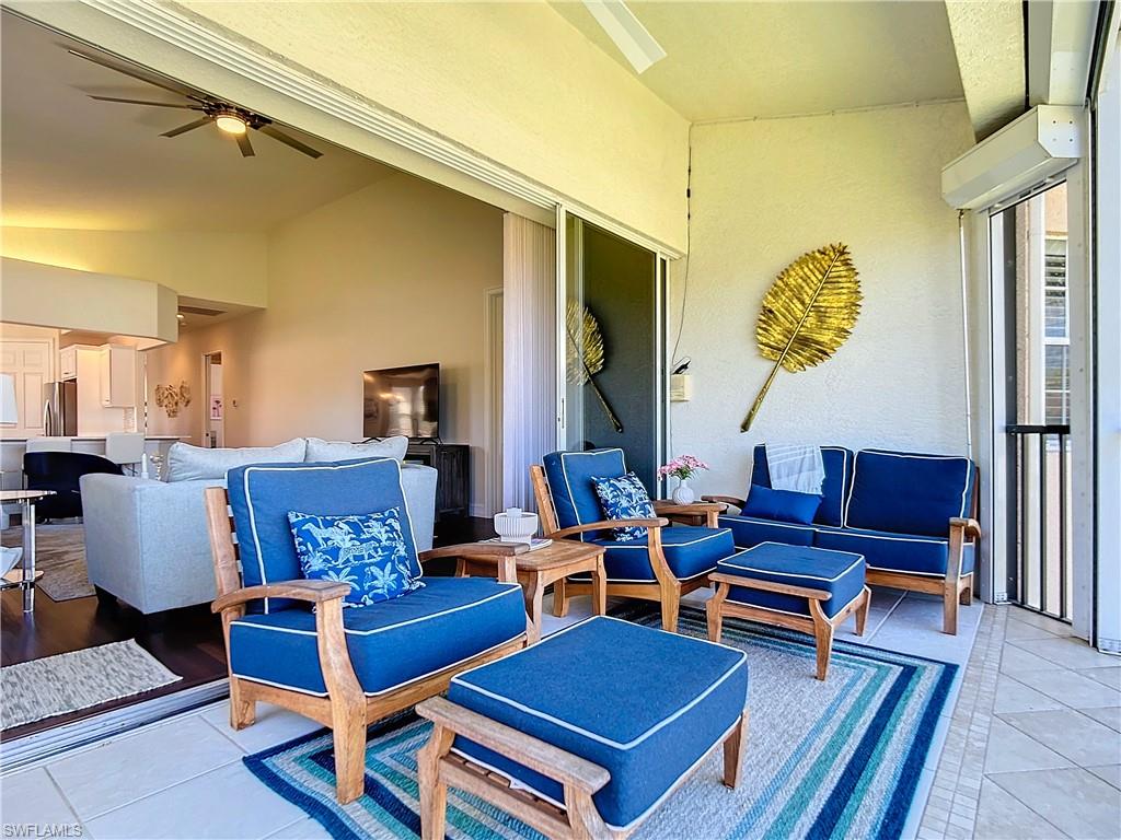 4752 Stratford Court, Unit 1404 Naples, FL 34105 - Photo 32 of 34 a living room with furniture a rug and a table