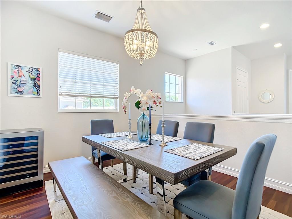 4752 Stratford Court, Unit 1404 Naples, FL 34105 - Photo 8 of 34 a view of a dining room with furniture a chandelier and wooden floor
