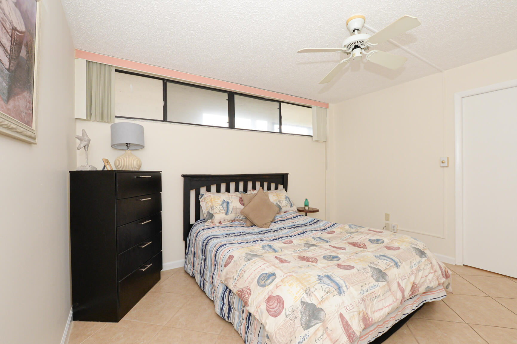 1950 Southwest Palm City Road, Unit 12103 Stuart, FL 34994 - Photo 12 of 37 a bedroom with a large bed and a chandelier