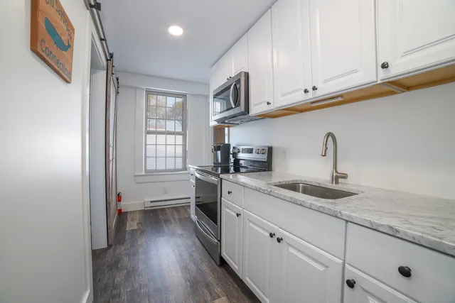 a kitchen with granite countertop a sink stainless steel appliances and cabinets
