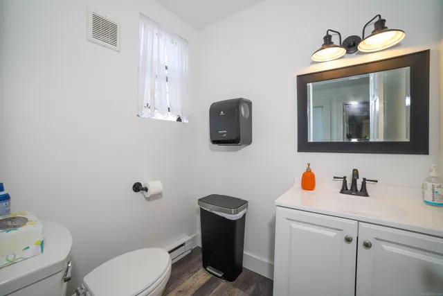 a bathroom with a toilet sink and mirror