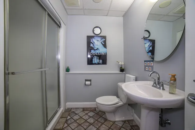 a bathroom with a toilet sink and mirror