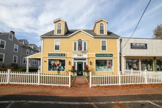 a front view of a residential apartment building with a bench