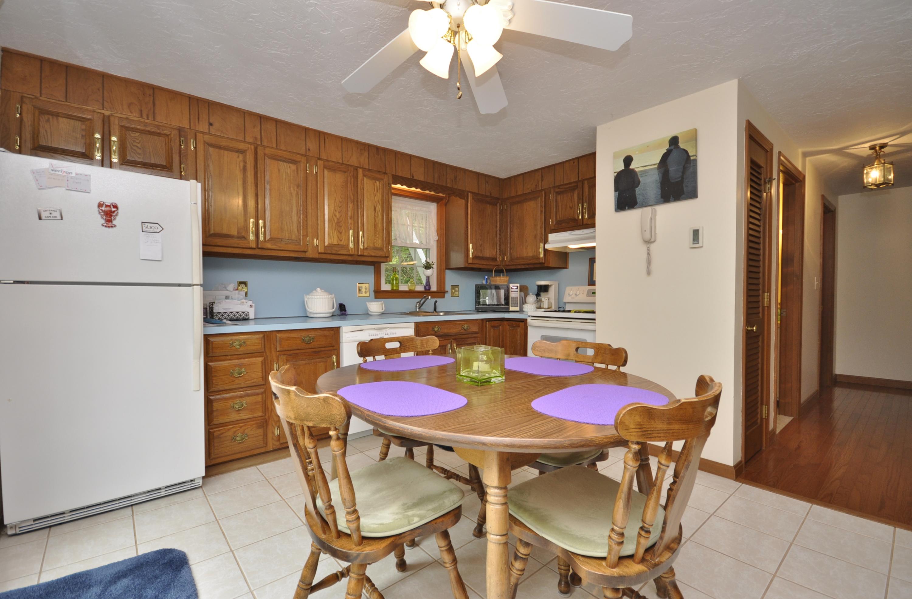 30 Longfellow Road Sagamore Beach, MA 02562 - Photo 7 of 21 a kitchen with a refrigerator a stove a dining table and chairs