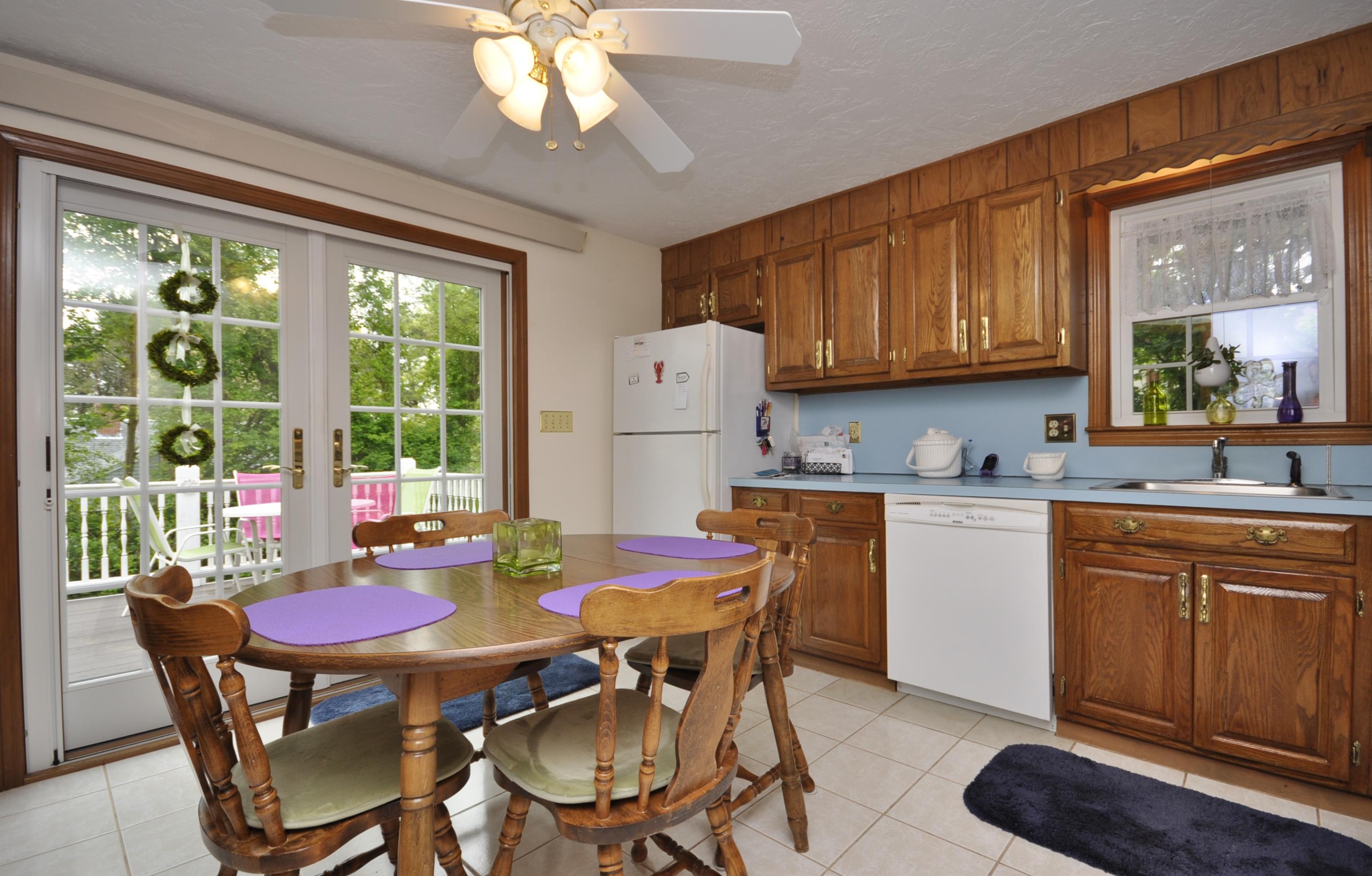 30 Longfellow Road Sagamore Beach, MA 02562 - Photo 8 of 21 a kitchen with stainless steel appliances granite countertop a dining table chairs and a refrigerator