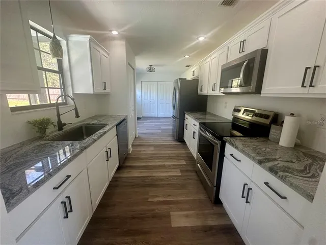 a walk in closet with wooden floor