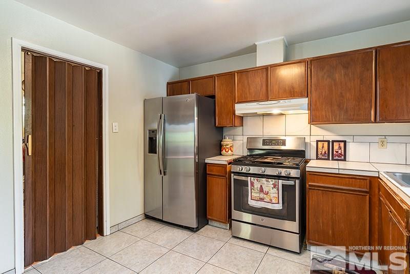 3450 Bryan Street Reno, NV 89503 - Photo 12 of 18 a kitchen with stainless steel appliances granite countertop a refrigerator and a stove top oven