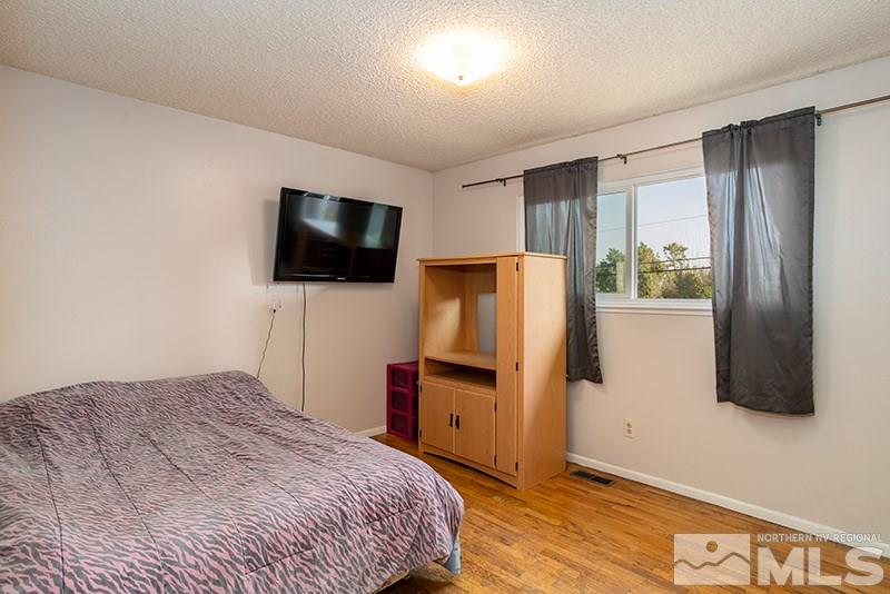3450 Bryan Street Reno, NV 89503 - Photo 14 of 18 a bedroom with a bed and a flat screen tv