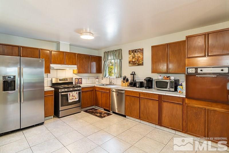 3450 Bryan Street Reno, NV 89503 - Photo 10 of 18 a kitchen with granite countertop stainless steel appliances a refrigerator a stove top oven and granite top