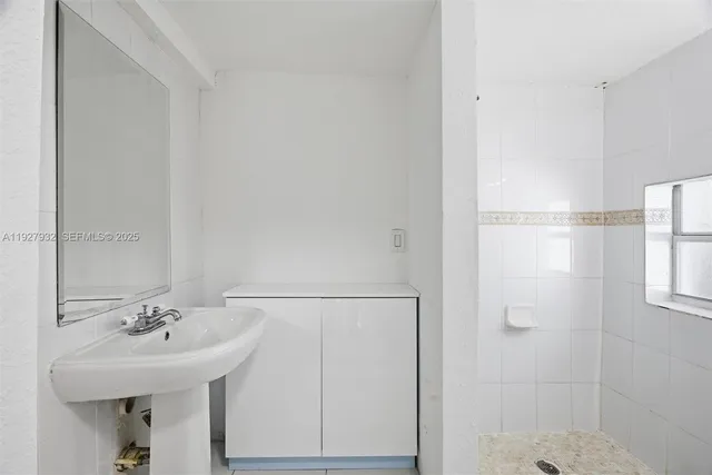 a bathroom with a sink a shower and a mirror