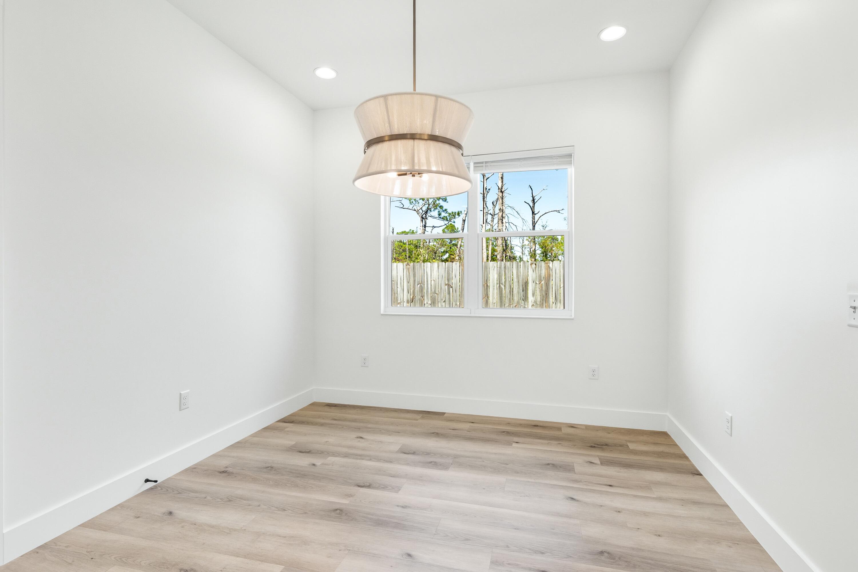 219 Loral Road Santa Rosa Beach, FL 32459 - Photo 12 of 26 an empty room with wooden floor and windows