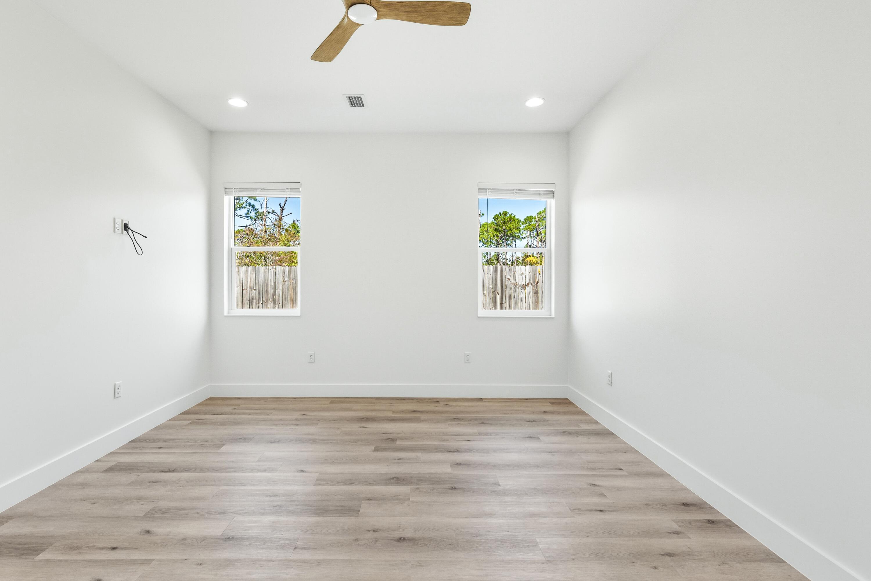 219 Loral Road Santa Rosa Beach, FL 32459 - Photo 13 of 26 an empty room with windows and wooden floor