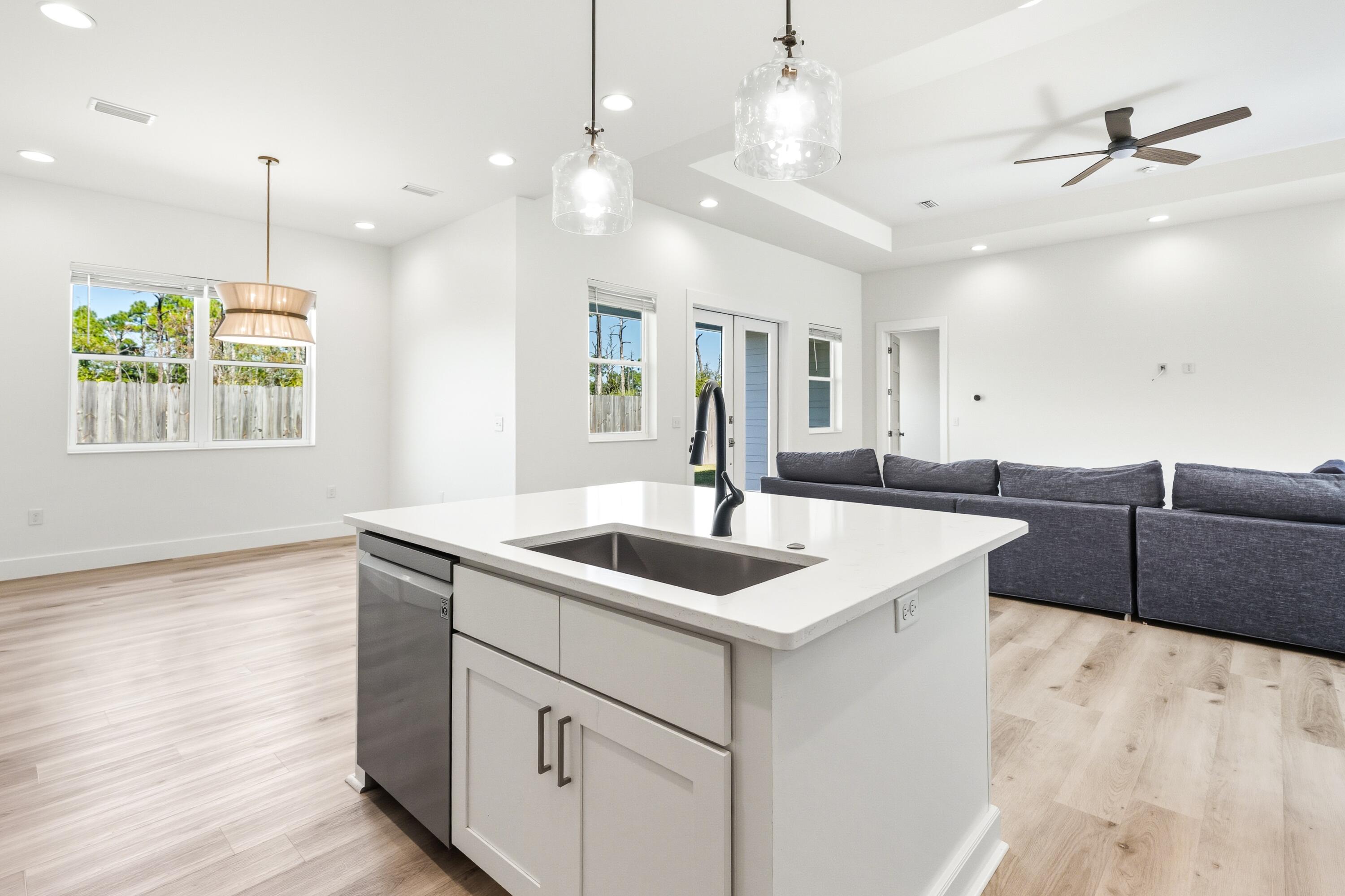 219 Loral Road Santa Rosa Beach, FL 32459 - Photo 10 of 26 a view of a kitchen counter top a sink and dishwasher with wooden floor