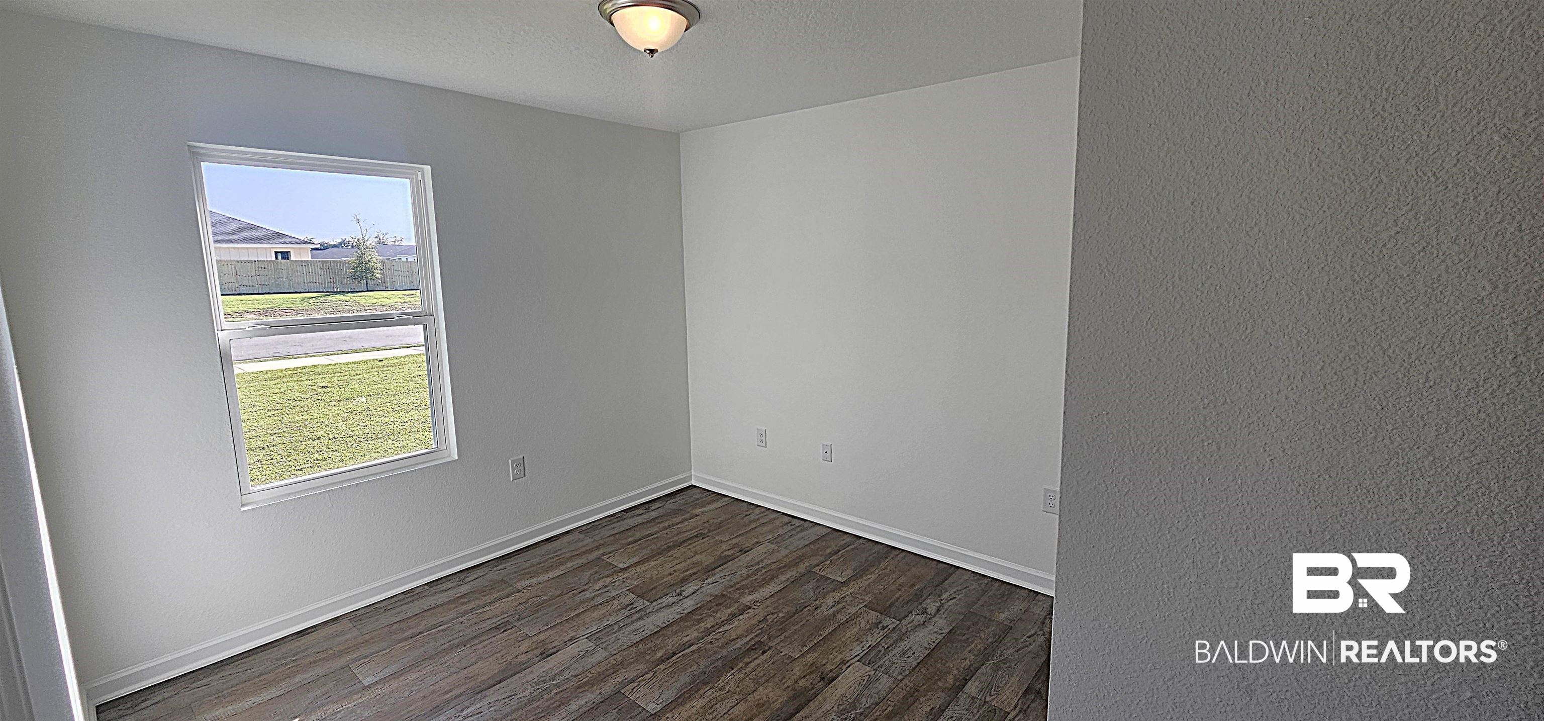 1148 Sweet Laurel Street Foley, AL 36535 - Photo 15 of 18 Empty room featuring dark wood-type flooring and a textured ceiling