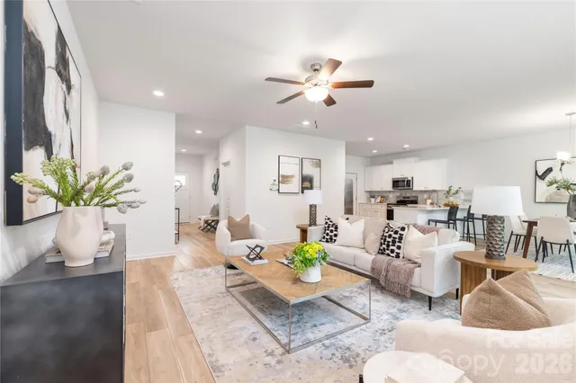 a living room with furniture flowerpot and a chandelier