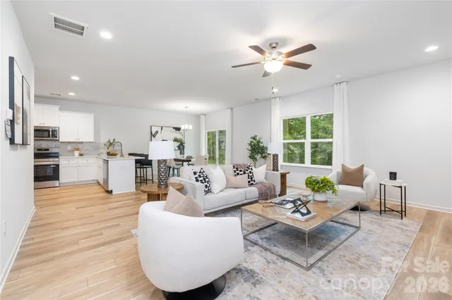 a living room with furniture and kitchen view