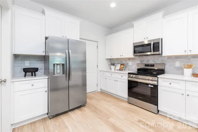 a kitchen with stainless steel appliances a refrigerator sink and microwave