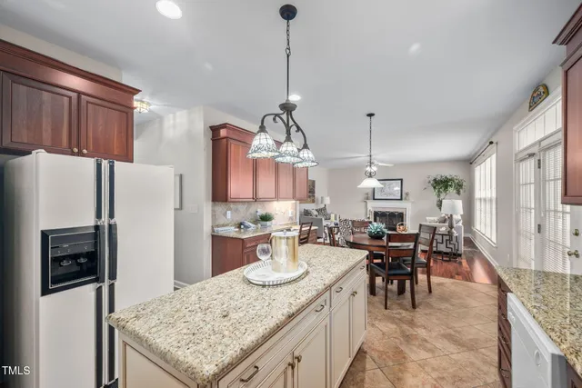 a kitchen with sink refrigerator dining table and chairs