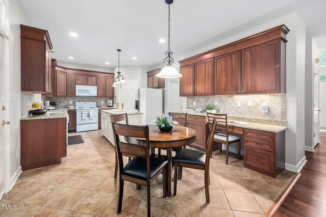 a kitchen with a dining table chairs and white cabinets