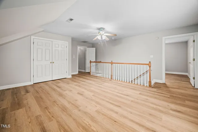 a view of empty room with wooden floor