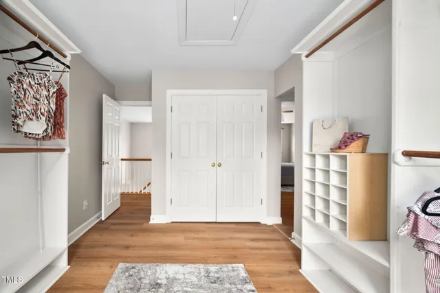 a view of a hallway with wooden floor and closet