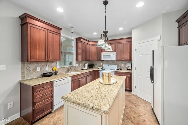 a kitchen with a refrigerator a sink and wooden cabinets