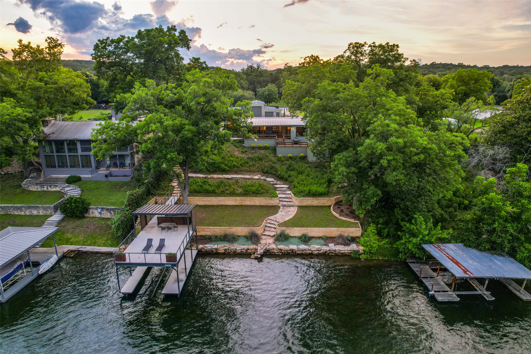 303 Lago Verde Road Austin, TX 78734 - Photo 36 of 39 A stunning lakefront property features a multi-tiered yard and a private boat dock for ultimate waterside enjoyment.