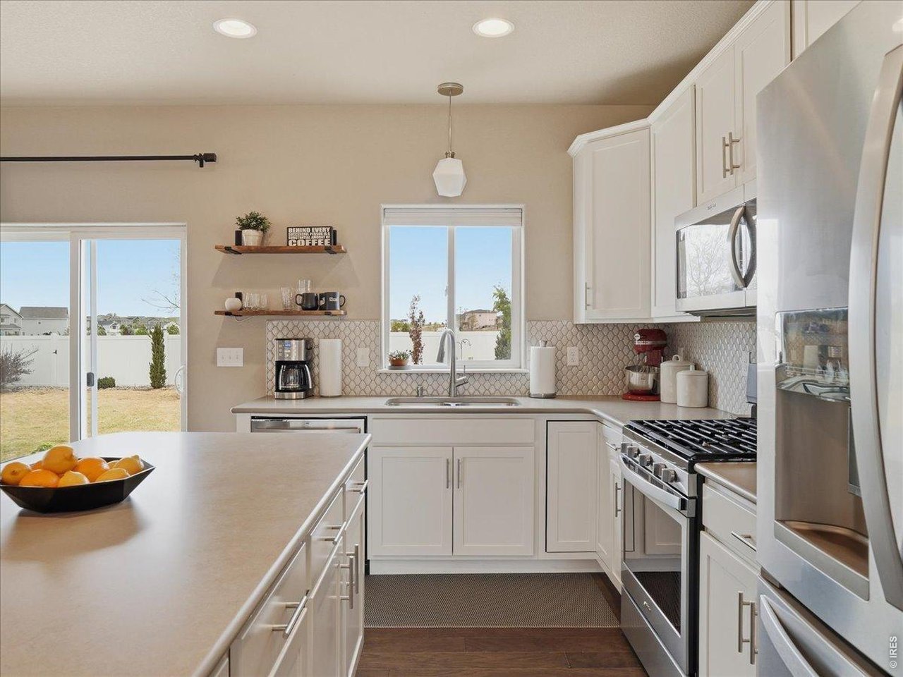 1766 Ruddlesway Drive Windsor, CO 80550 - Photo 5 of 50 a kitchen with stainless steel appliances a sink a stove and a refrigerator