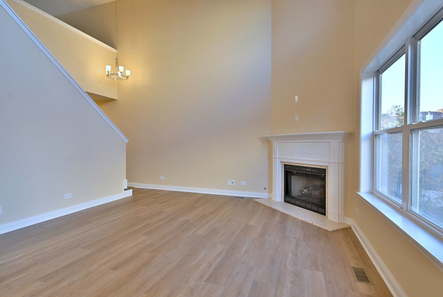 3208 Raphael Court St. Charles, IL 60175 - Photo 9 of 47 a view of an empty room with wooden floor fireplace and a window