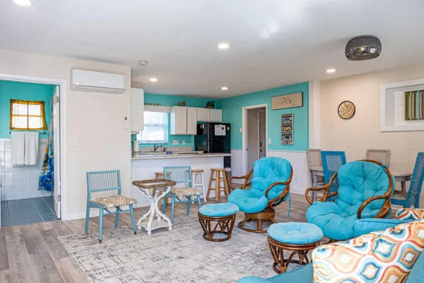 a living room with furniture and a view of kitchen