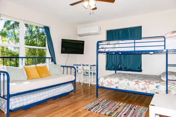 a bedroom with a bed a flat screen tv and a chandelier