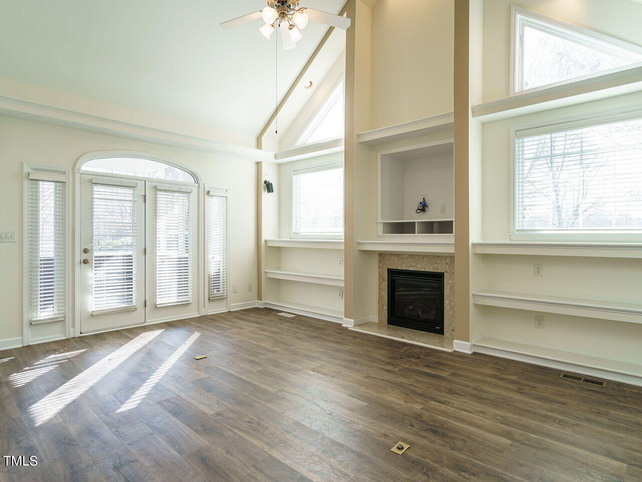 600 Competition Road Raleigh, NC 27603 - Photo 5 of 42 an empty room with wooden floor fireplace and windows