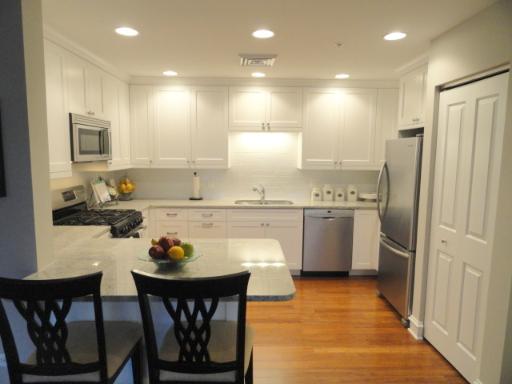 970 Harris Road, Unit 222 Grayslake, IL 60030 - Photo 3 of 11 a kitchen with stainless steel appliances granite countertop a stove a sink a refrigerator dining table and chairs