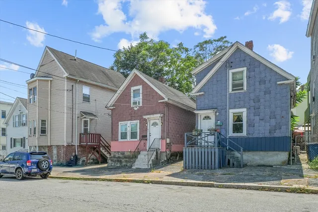 a view of a brick house with many windows and a small yard