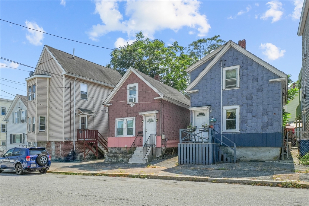 58-64 Railroad Street Lawrence, MA 01841 - Photo 1 of 9 a view of a brick house with many windows and a small yard