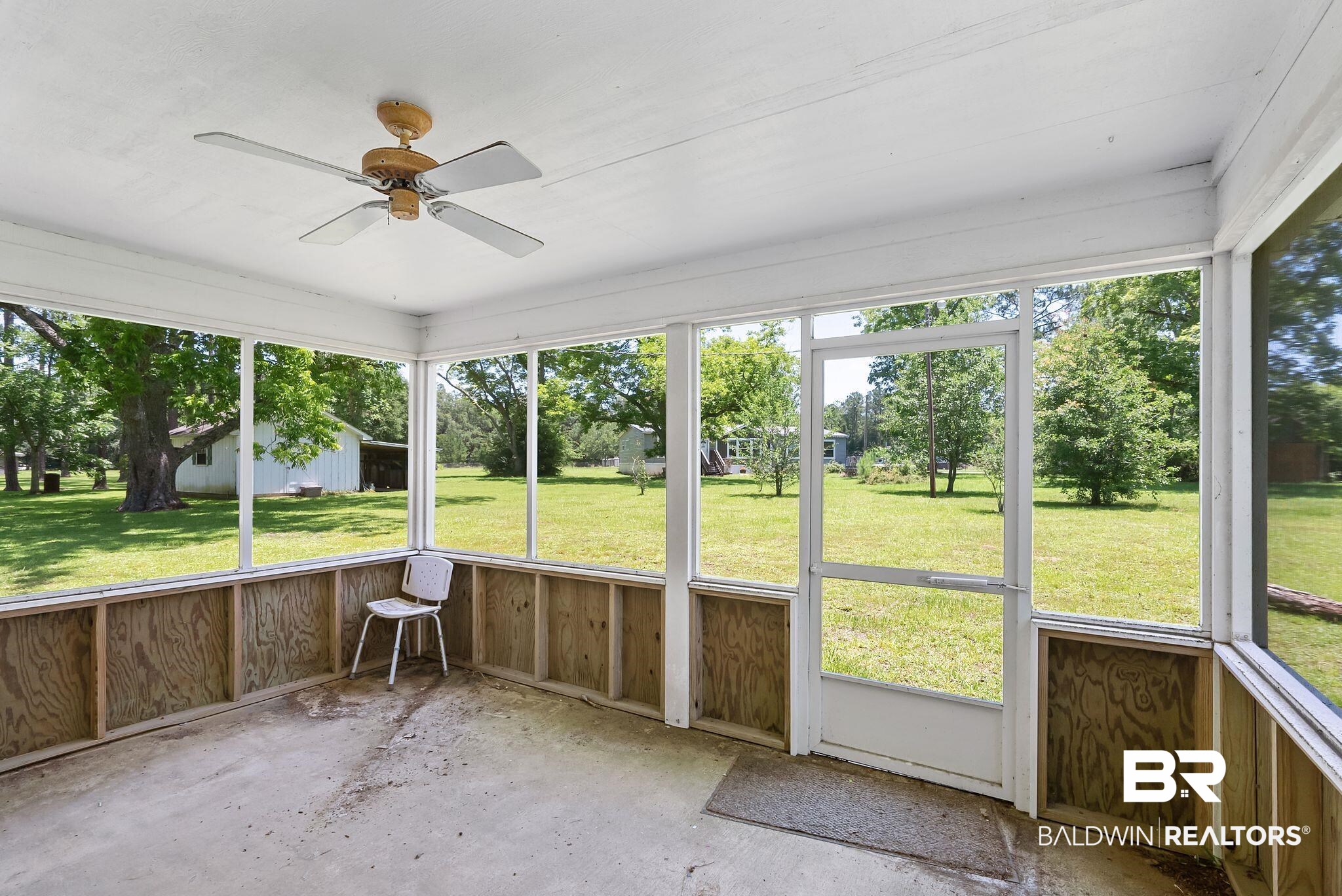 20540 Lacey Road Silverhill, AL 36576 - Photo 21 of 40 Screened porch featuring a ceiling fan, concrete flooring, and a screened door leading to the exterior