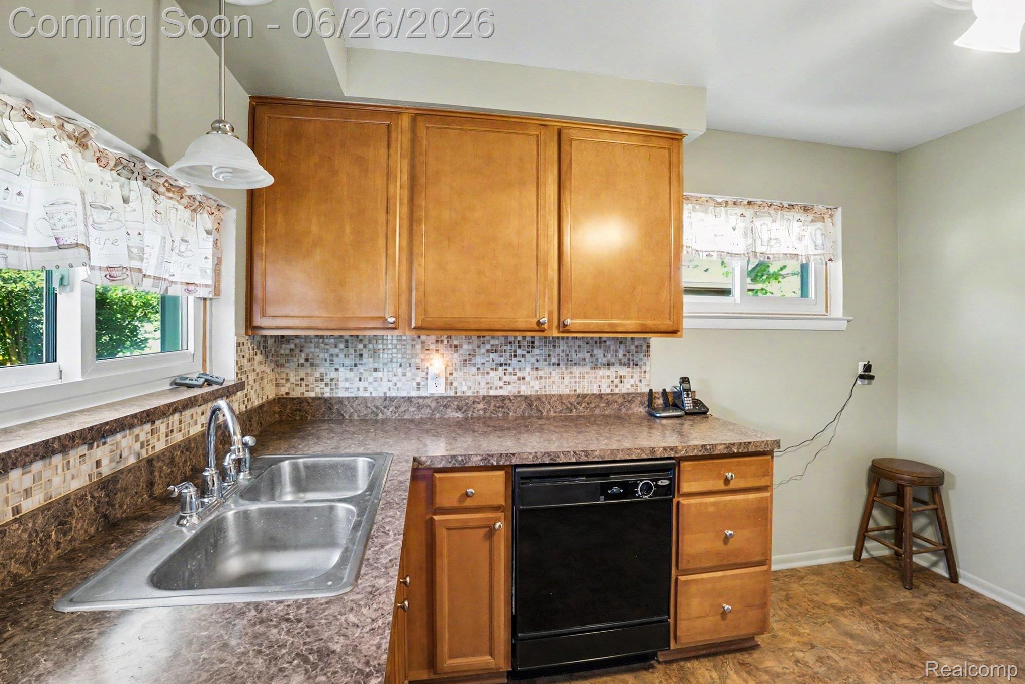 1209 Massoit Road Clawson, MI 48017 - Photo 10 of 25 Kitchen featuring warm wood-finish cabinetry, a double basin stainless steel sink, and a built-in black dishwasher