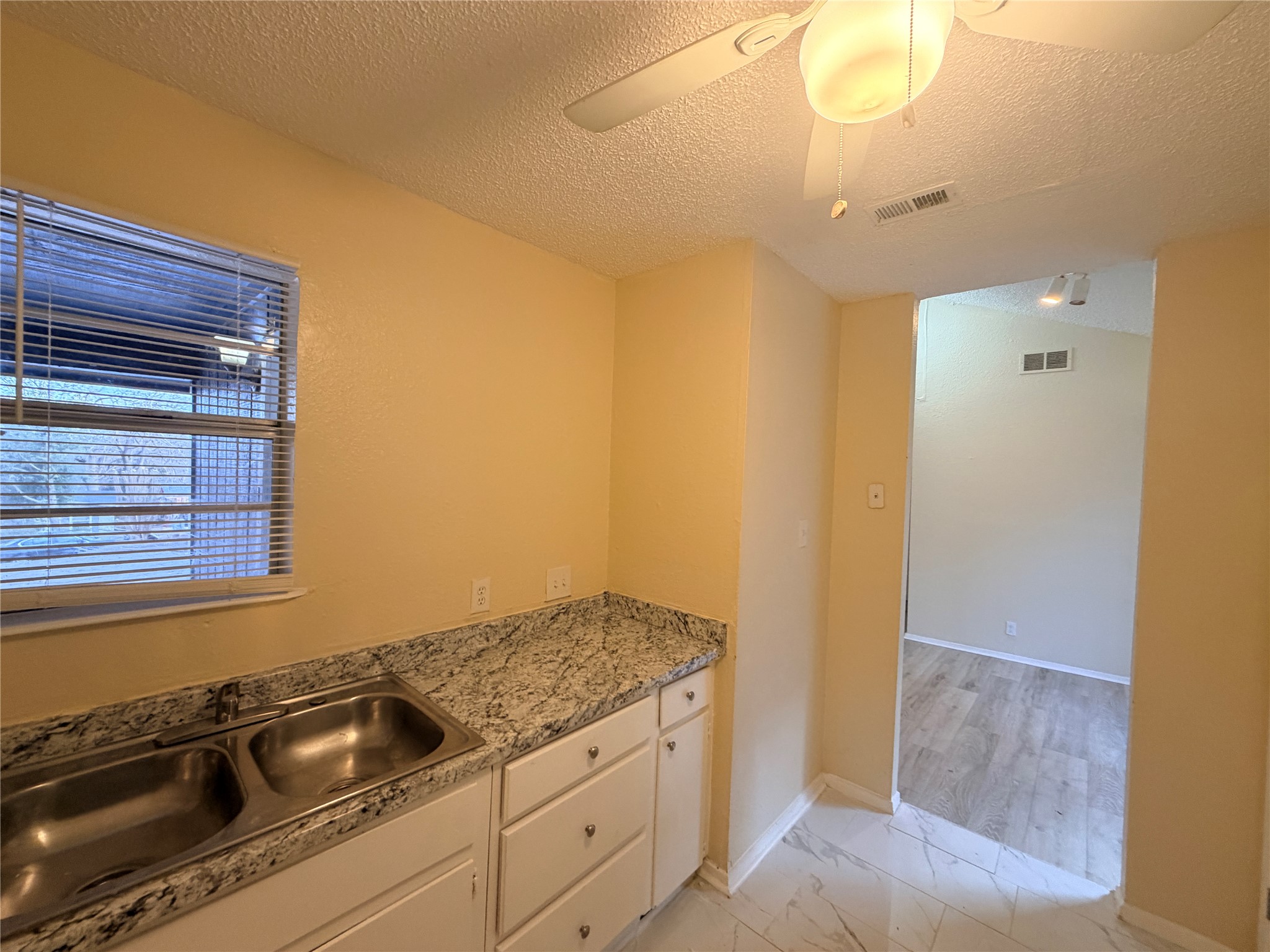 4302 Scottsdale Road, Unit A Austin, TX 78721 - Photo 12 of 30 a kitchen with granite countertop a sink and cabinets