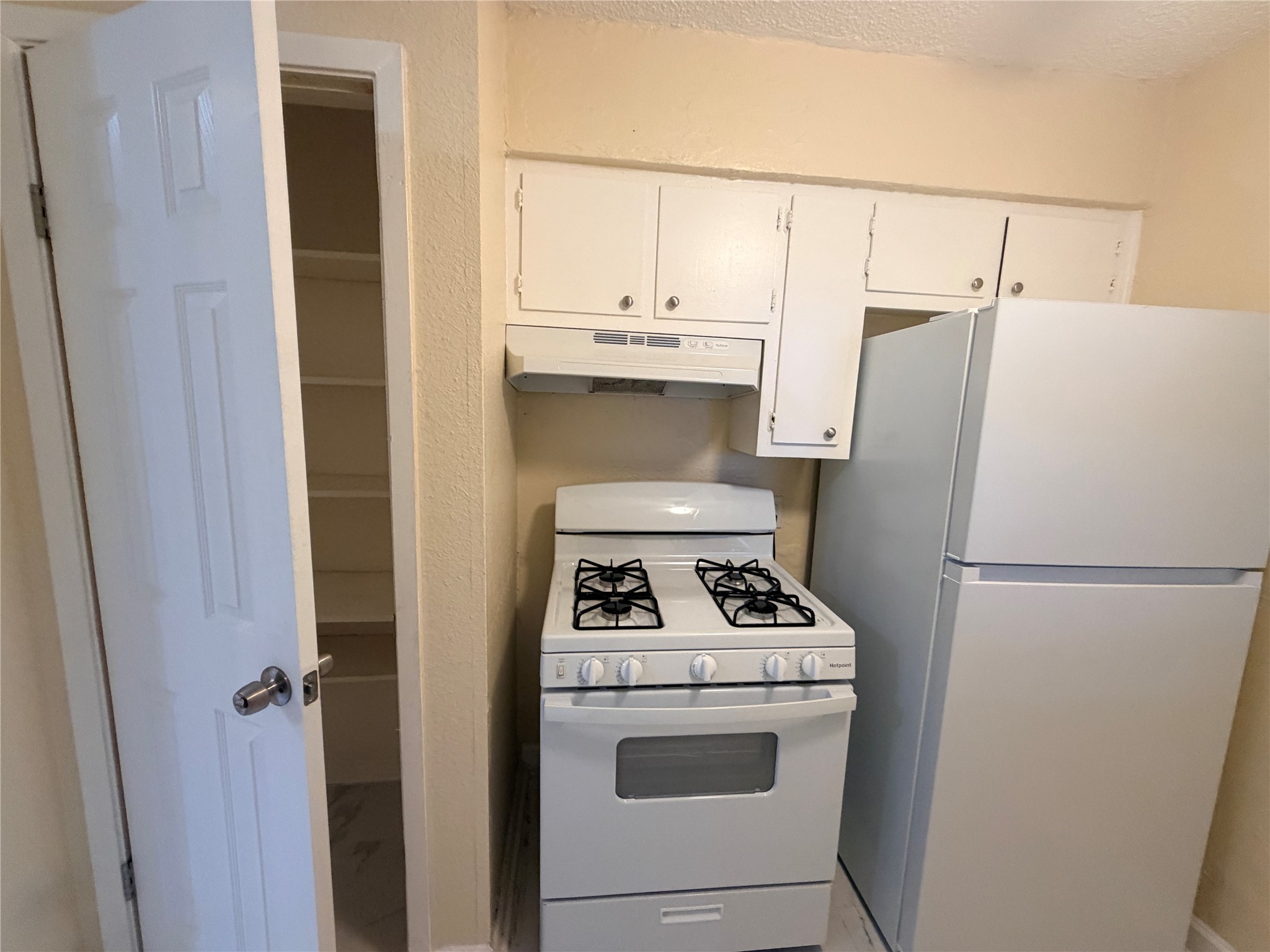 4302 Scottsdale Road, Unit A Austin, TX 78721 - Photo 13 of 30 a white refrigerator freezer and a stove sitting inside of a kitchen