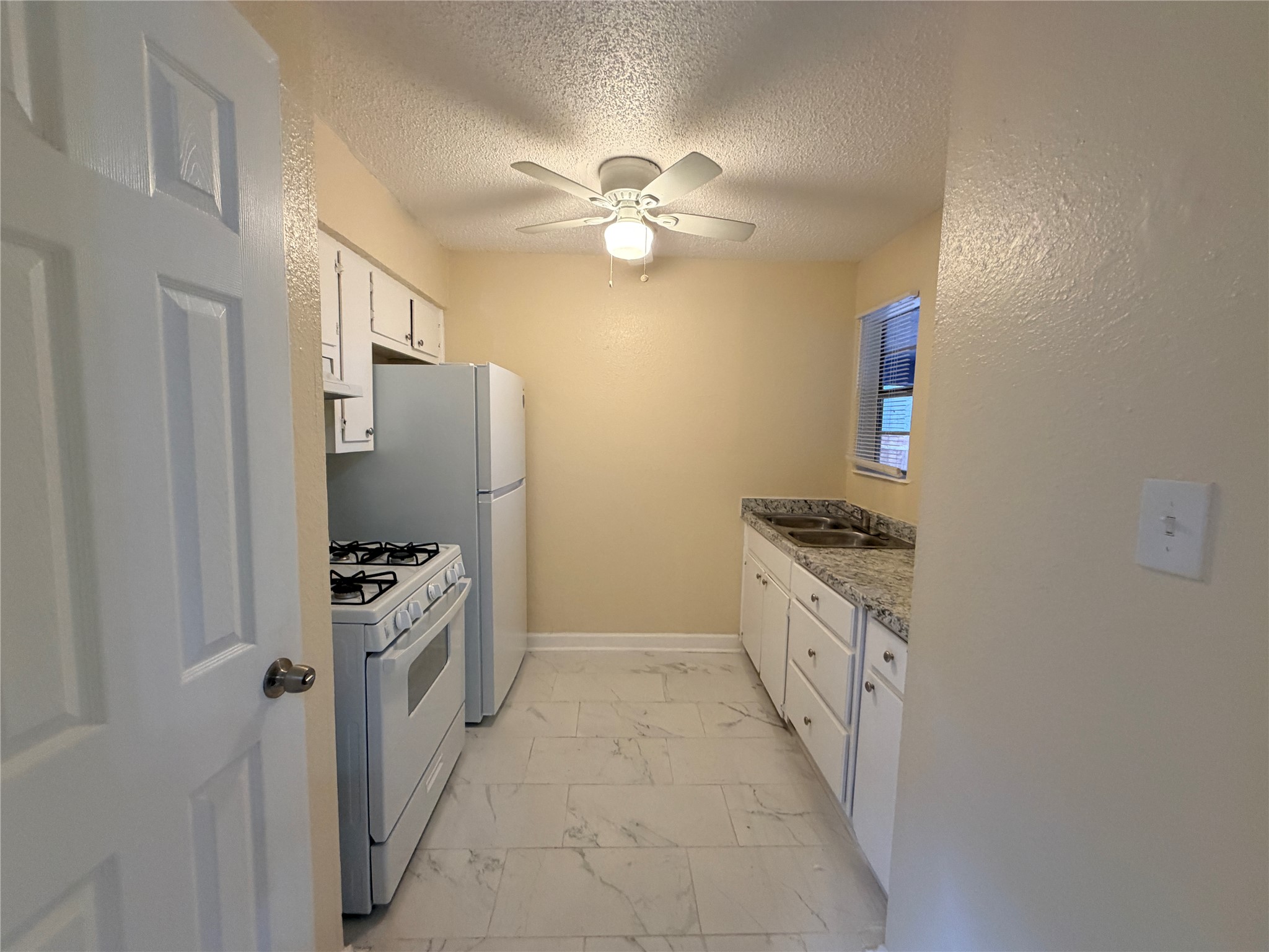 4302 Scottsdale Road, Unit A Austin, TX 78721 - Photo 10 of 30 a kitchen with granite countertop a stove top oven a sink and dishwasher