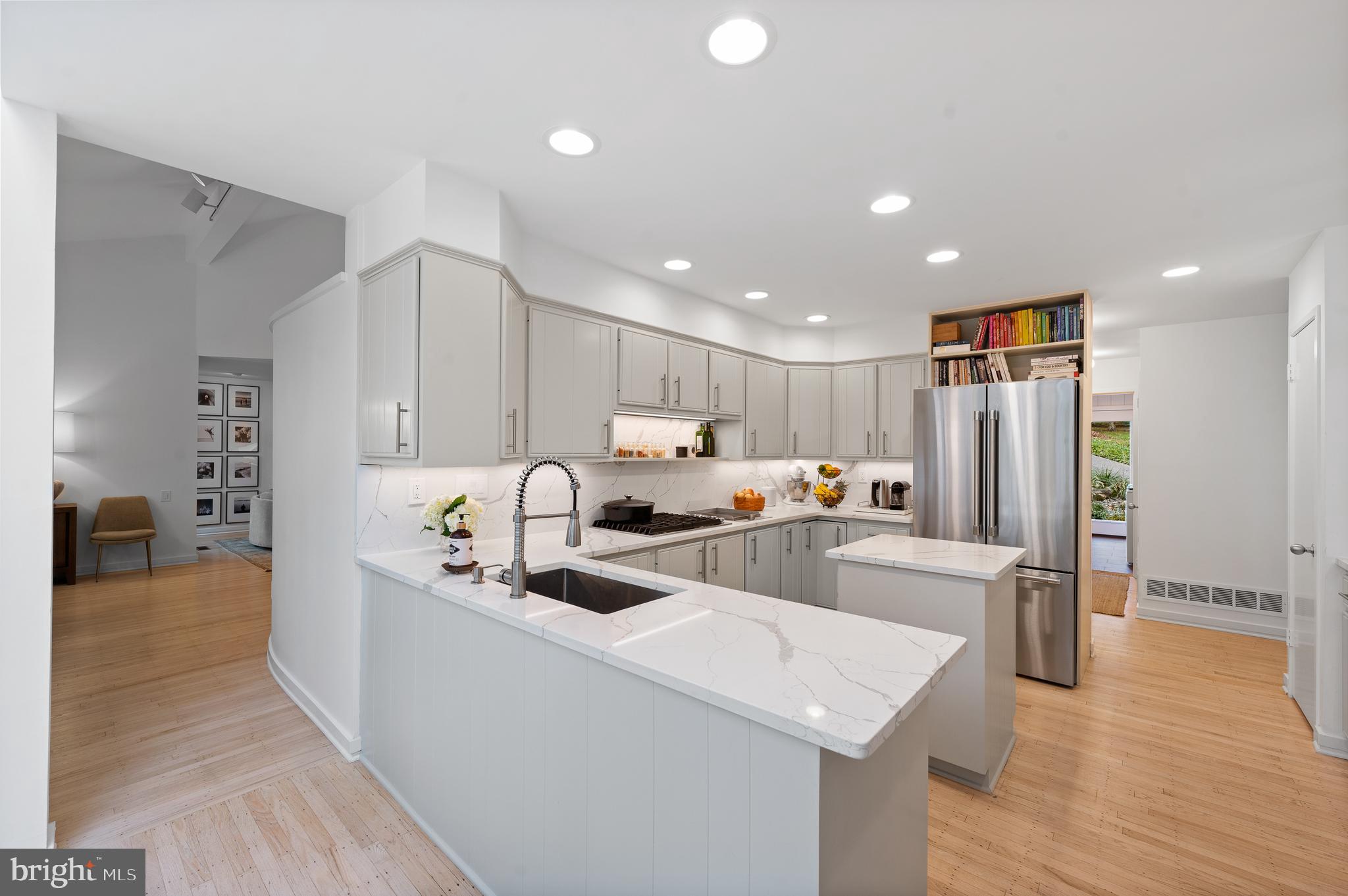 309 Valley Place Radnor, PA 19087 - Photo 6 of 29 a view of a kitchen with kitchen island a white counter top space a sink stainless steel appliances and cabinets