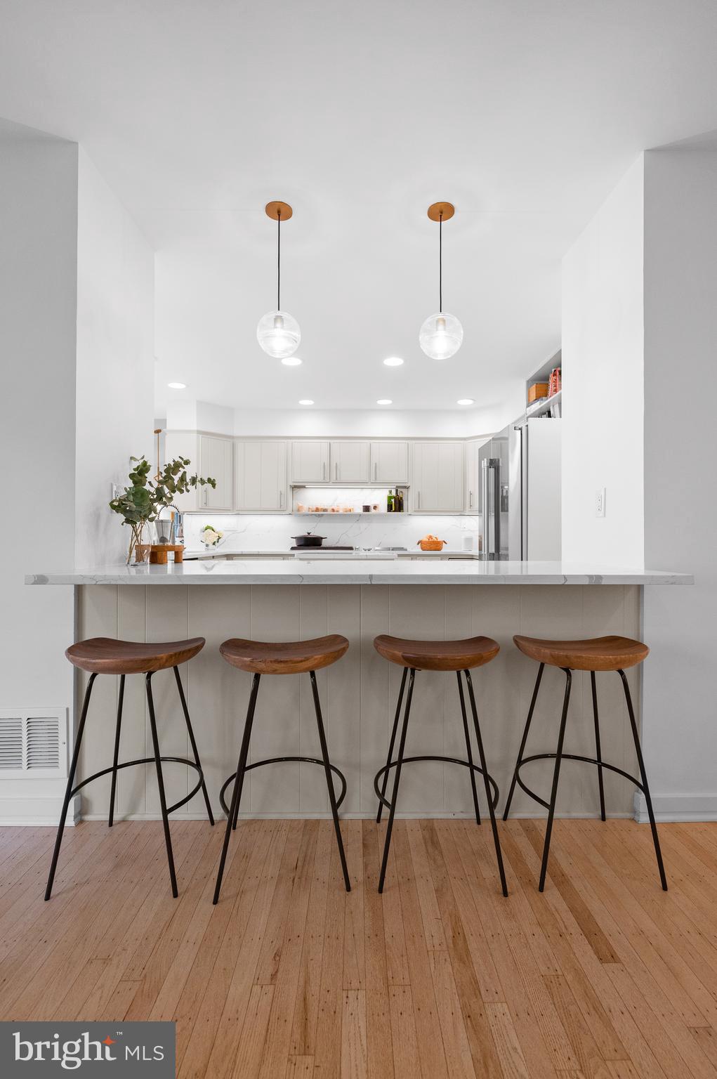 309 Valley Place Radnor, PA 19087 - Photo 8 of 29 a kitchen with stainless steel appliances a dining table chairs and wooden floor