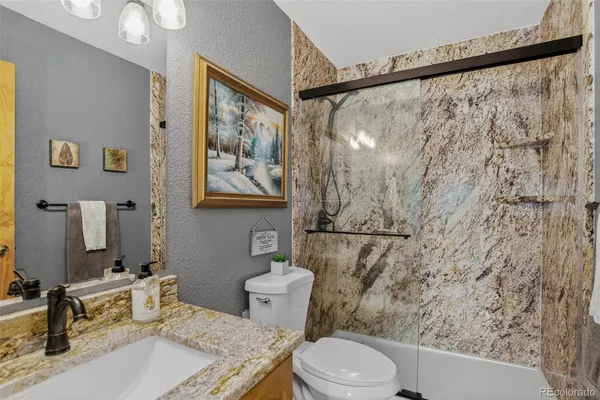 a bathroom with a sink toilet and shower