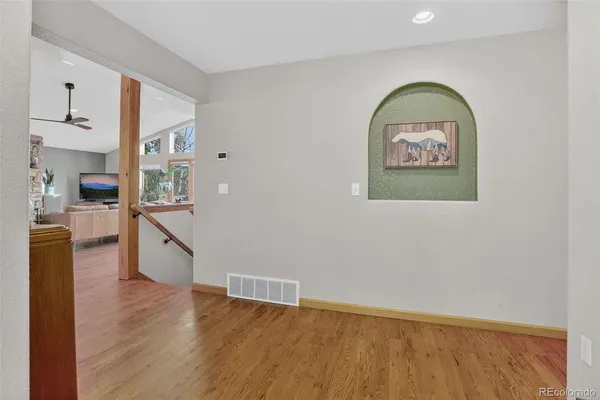 a view of a kitchen with wooden floor and a window