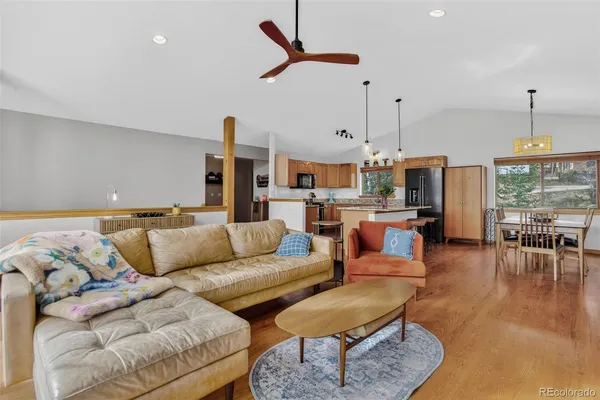 a living room with furniture kitchen view and a chandelier