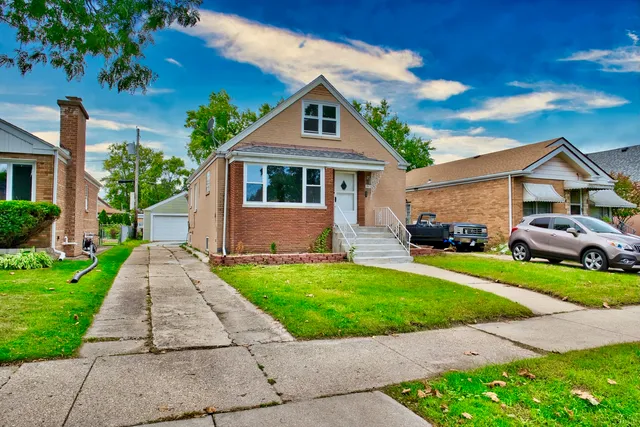 a front view of a house with a yard and potted plants